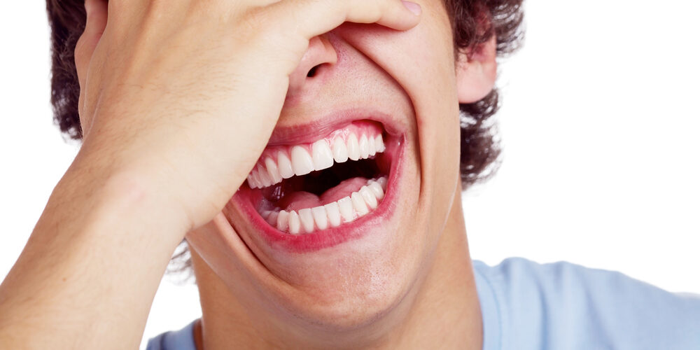 Image of young man enjoying the health benefits of a big laugh